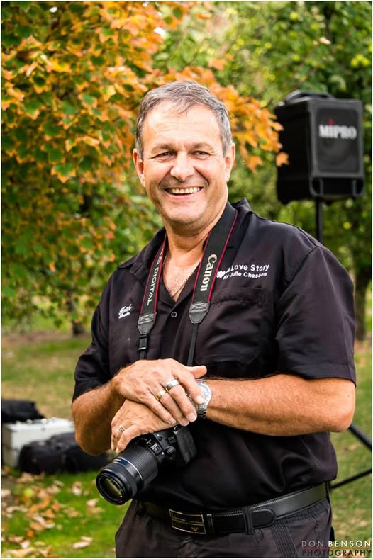 Keith smiling with his camera beside the sound system